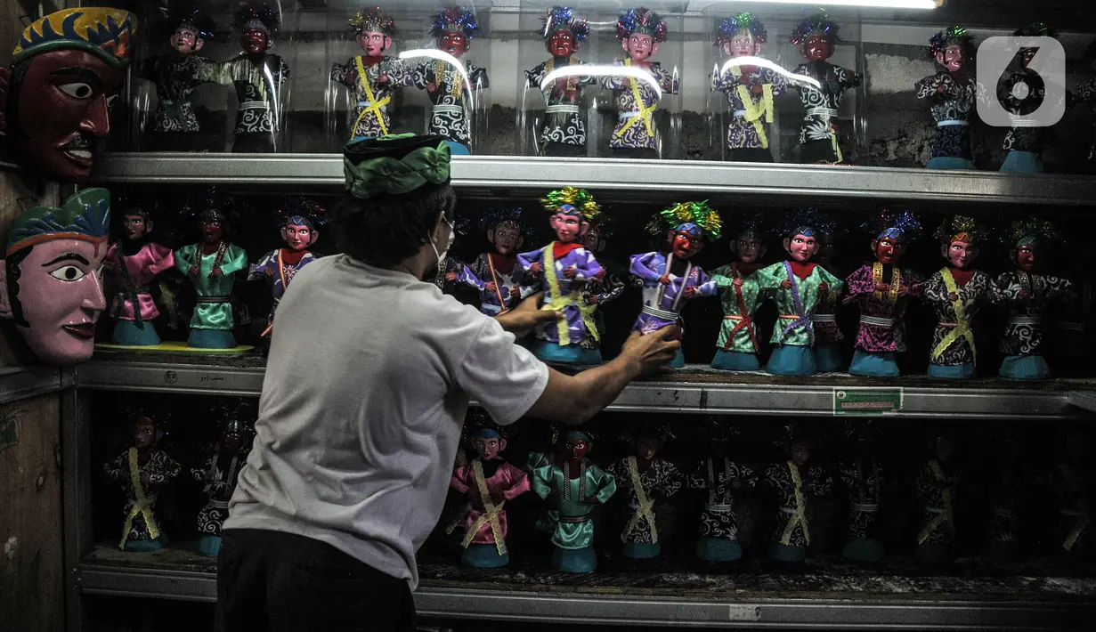 Masudi alias Bang Ntong Salam (40) menata sejumlah miniatur ondel-ondel di Jalan Gang 3, Kelurahan Pondok Kopi, Kecamatan Duren Sawit, Jakarta Timur, Selasa (19/10/2021). (merdeka.com/Iqbal S. Nugroho)