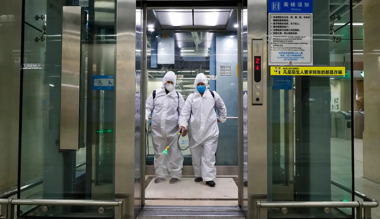 Para staf melakukan disinfeksi di sebuah elevator di area bawah tanah Stasiun Kereta Api Hankou di Wuhan, Provinsi Hubei, 23 Maret 2020. Masyarakat perlu mendaftarkan nama asli mereka jika ingin menggunakan transportasi umum atau taksi di kota tersebut. (Xinhua/Shen Bohan)