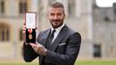 Mantan pesepak bola, Sir David Beckham menunjukkan medali setelah dinobatkan gelar baru oleh raja Inggris, Charles III di Kastil Windsor, Berkshire, Inggris, Selasa (04/11/2025) waktu setempat. (AP Photo/Pool/Andrew Matthews)
