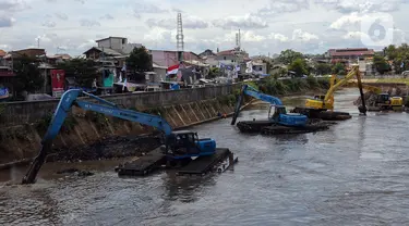 Ekskavator mengeruk endapan material lumpur pada aliran Kali Ciliwung di Jakarta, Selasa (16/1/2023). Proyek ini dilakukan untuk mengurangi pendangkalan kali dan bagian dari program pencegahan penanggulangan banjir yang sudah masuk musim penghujan. (merdeka.com/Imam Buhori)