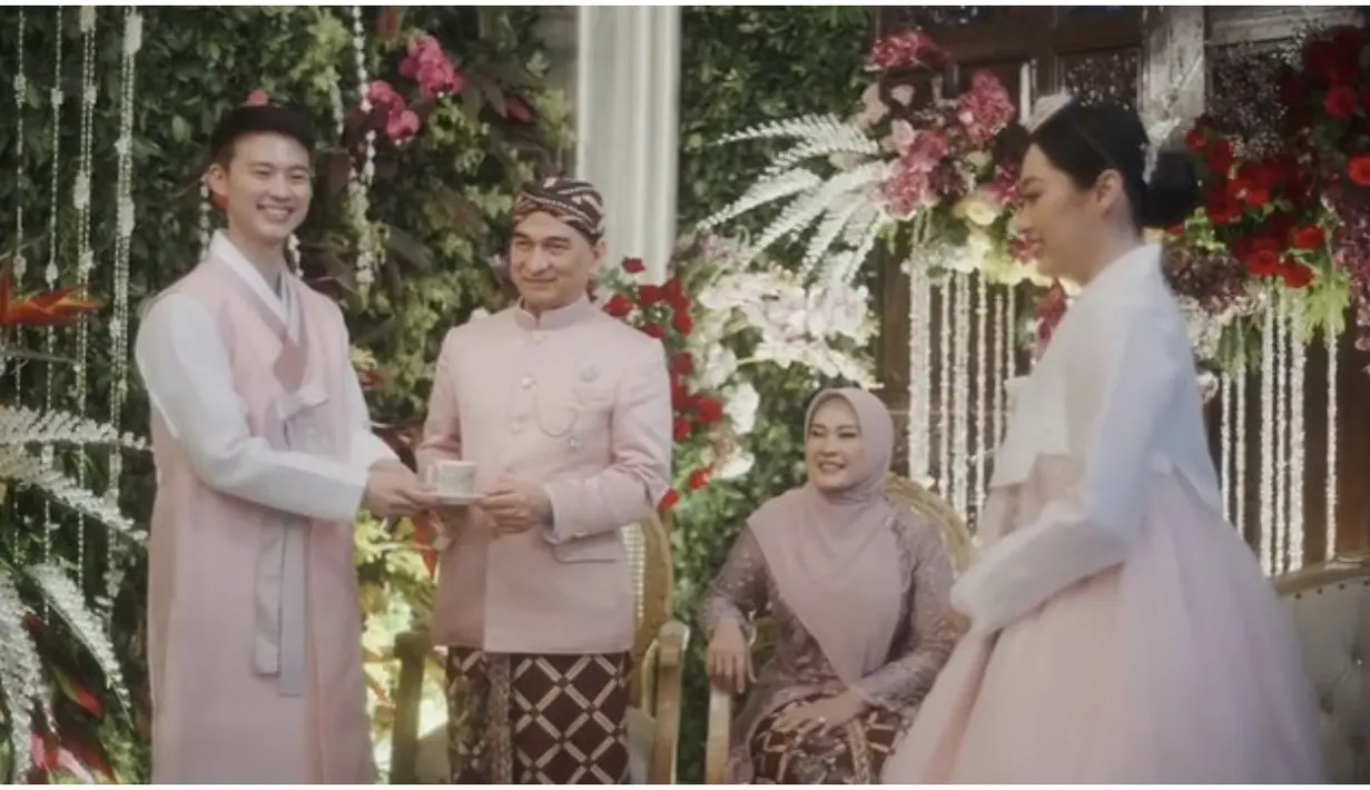Kedua keluarga memadukan dua tradisi yang kental. Dalam balutan Hanbok, Rizka tampak seperti orang Korea. Gaya makeup dan rambut ditata sedemikian rupa, cantik bikin pangling. [Foto: youtube.com/sanghoya/]