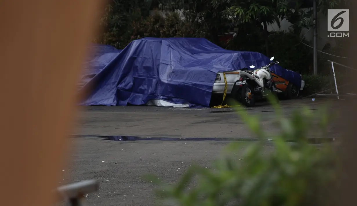 Terpal menutupi kendaraan yang terparkir di halaman Polsek Ciracas seusai perusakan dan pembakaran di Jakarta, Rabu (12/12). Belum diketahui tujuan massa mendatangi Polsek Ciracas hingga terjadi pembakaran pada dinihari tadi (Liputan6.com/Herman Zakharia)