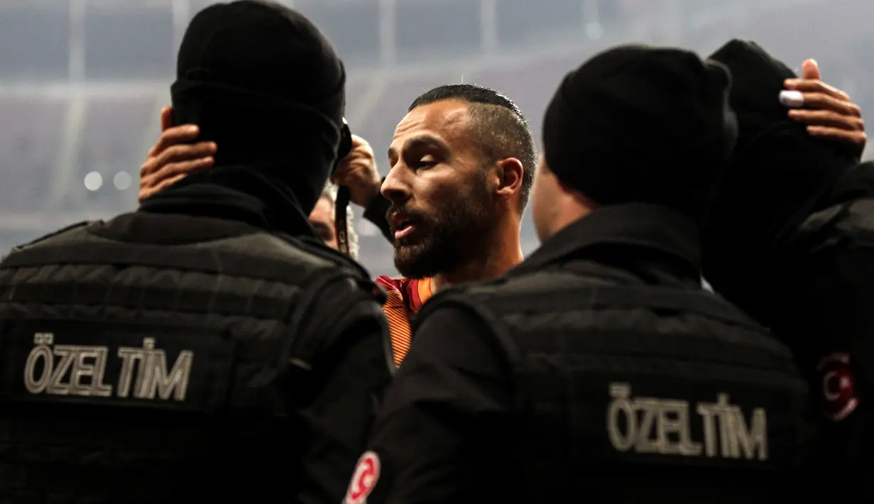 Pemain Galatasaray, Yasin Oztekin memeluk petugas polisi setelah mencetak gol saat melawan Gaziantepspor dalam Liga Super Turki di Istanbul, Minggu (11/12). Itu dilakukan Oztekin sebagai ungkapan duka cita atas tragedi ledakan bom Besiktas (AFP PHOTO/STR)