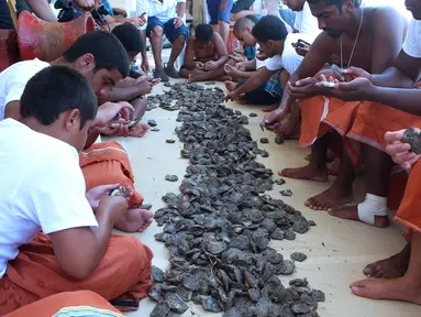 Sejumlah penyelam mengupas cangkang kerang yang sudah ditangkap selama musim berburu mutiara tahunan di lepas pantai kota pelabuhan Khairan, Kuwait (2/8). Warga Kuwait Berburu mutiara setiap tahun sekali. (AFP PHOTO/Yasser Al-Zayyat)