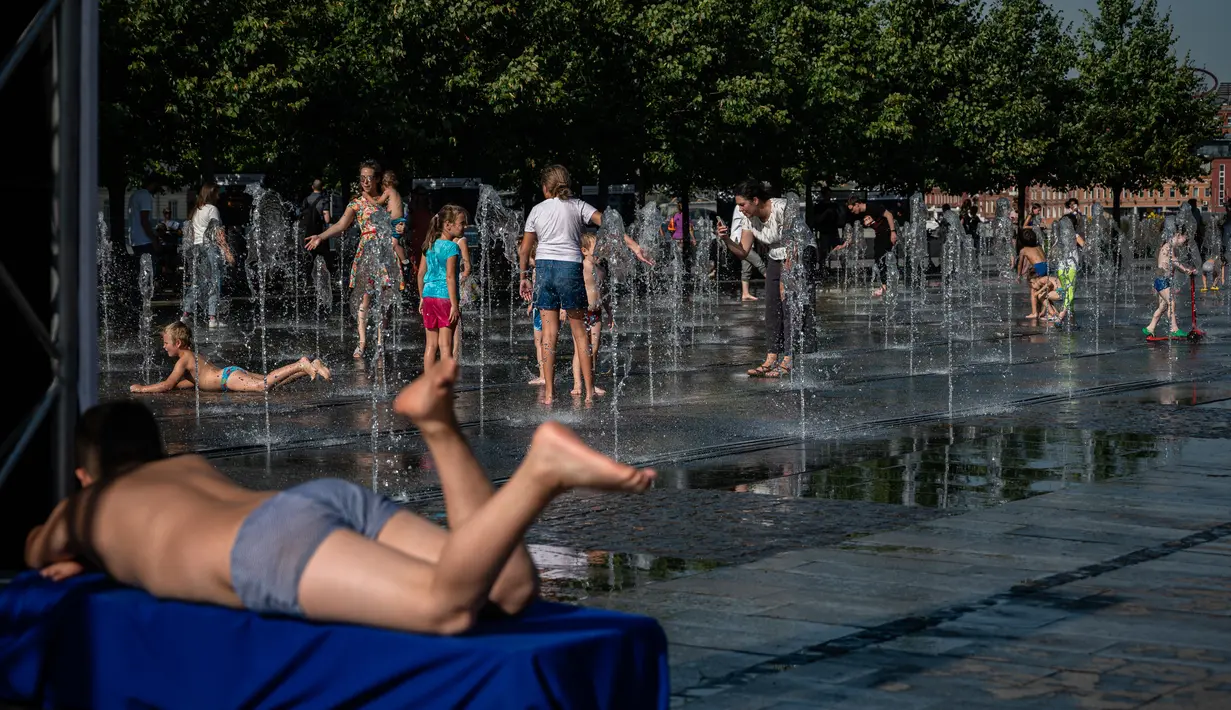 Anak-anak mendinginkan diri di air mancur Taman Muzeon saat suhu udara mendekati 31 derajat celcius di Moskow (31/8/2020). Akibat perubahan suhu tersebut, Moskow menjadi salah satu wilayah terpanas di Rusia. (AFP/DIMITAR DILKOFF)