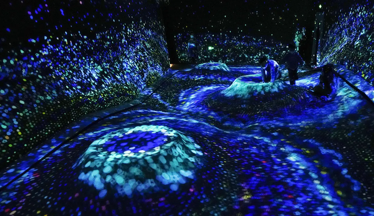 Anak-anak bermain instalasi proyeksi seni digital bertajuk "Soft Terrain in Granular Topography, A Whole Year per Year" di museum "teamLab Massless" yang baru dibuka di Beijing, China, Senin (26/12/2022). Berbasis di Tokyo teamLab membuat museum seni digital yang memamerkan berbagai karya seni interaktif di dalam pusat perbelanjaan di ibu kota Beijing. (AP Photo/Andy Wong)