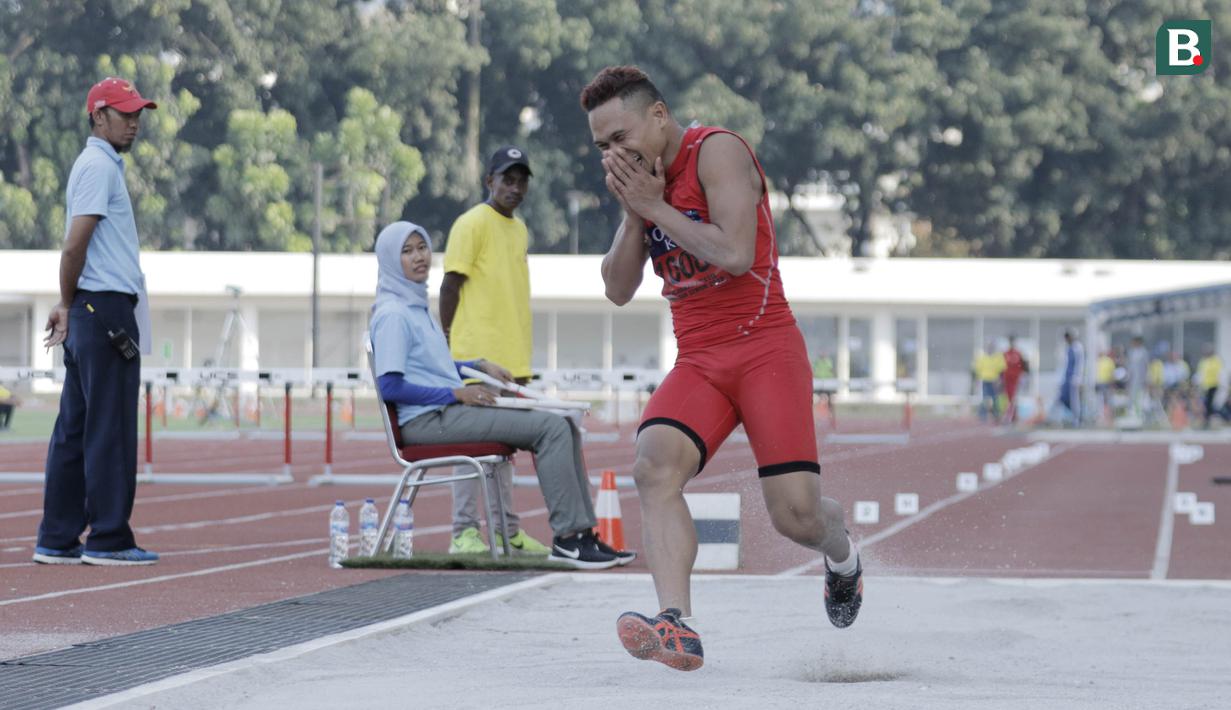 Atlet lompat jauh DKI Jakarta, Noval, tertawa usai melakukan lompatan saat kejurnas atletik di Stadion Madya, Senayan, Jakarta, Rabu (9/5/2018). Noval berhasil menjadi juara dengan loncatan sejauh 7,14 Meter. (Bola.com/M Iqbal Ichsan)