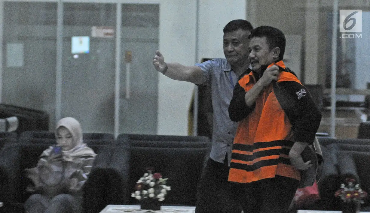 Bupati Jombang Nyono Suharli Wihandoko dikawal petugas usai menjalani pemeriksaan perdana di Gedung KPK, Jakarta, Rabu (7/2). Uang tersebut dikutip oleh Plt Kadis Kesehatan Jombang Inna Sulistyowati dari 34 puskesmas. (Liputan6.com/Herman Zakharia)