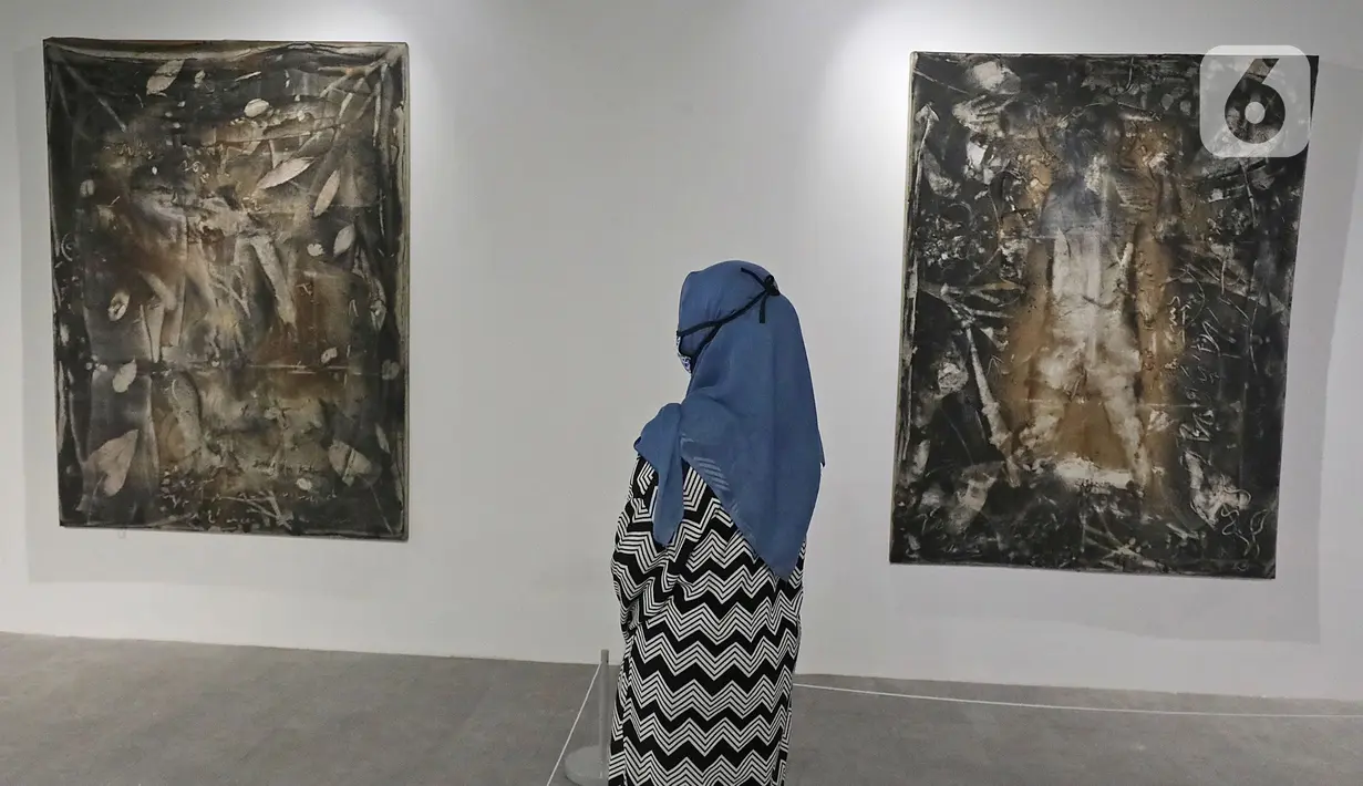 Pengunjung melihat karya yang dipajang dalam pameran Pulih di Pasar Seni, Ancol, Jakarta, Sabtu (14/11/20). Sambil menikmati karya seni, pengunjung juga diharapkan mematuhi protokol kesehatan dan kebersihan yang diterapkan pihak Pasar Seni Ancol. (Liputan6.com/Herman Zakharia)