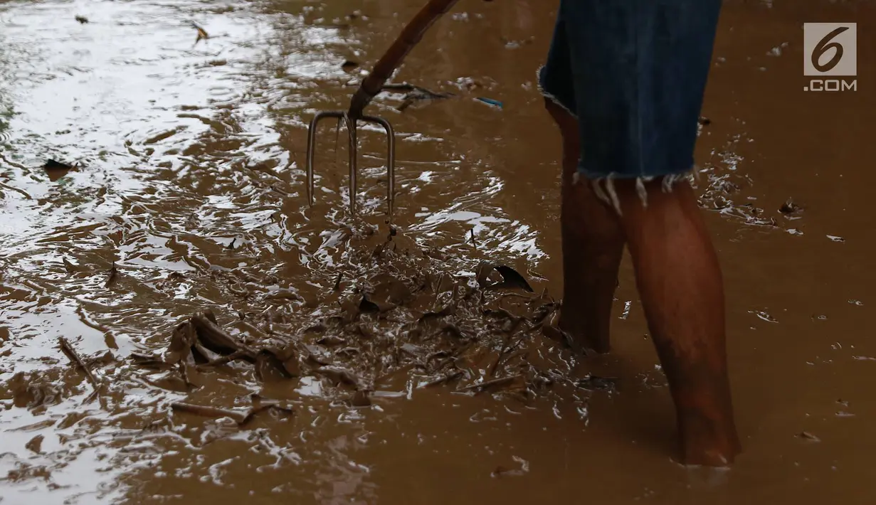 Warga membersihkan lumpur dari banjir yang menggenangi Gang Arus Dalam di Cawang, Jakarta Timur, Rabu (24/4). Banjir kiriman dari Bogor yang menggenangi kawasan tersebut menyisakan lumpur dan sampah sehingga menganggu aktivitas warga. (Liputan6.com/Immanuel Antonius)