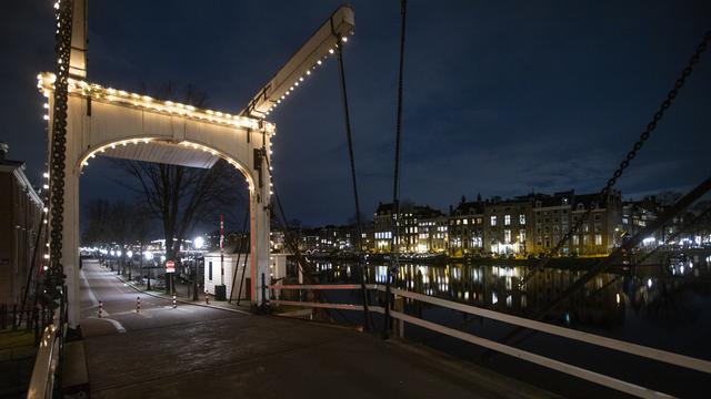 <span>Sebuah jembatan yang sepi terlihat selama jam malam di pusat kota Amsterdam, Sabtu (23/1/2021). Belanda memasuki fase terberat dari pembatasan anti-virus Corona hingga saat ini. (AP Photo/ Peter Dejong)</span>