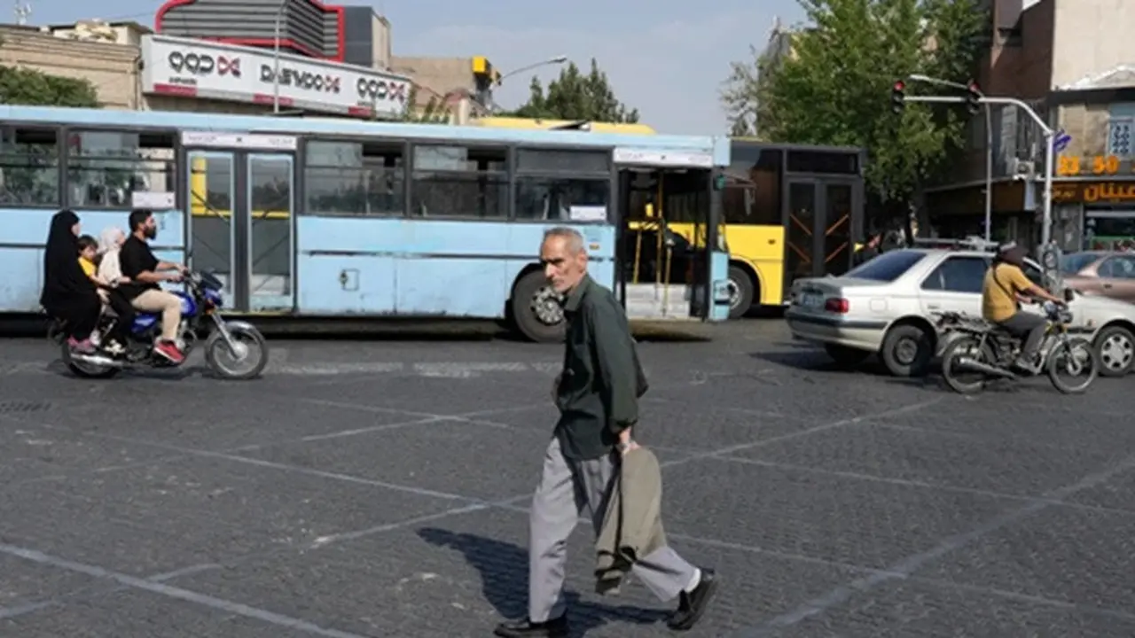 Seorang pria melintasi persimpangan pada hari musim panas yang terik di pusat kota Teheran, Iran, Senin, (21/7/2025).