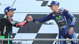 Pembalap Movistar Yamaha dan Tim Yamaha Tech 3, Maverick Vinales dan Johann Zarco saling berjabat tangan di atas podium MotoGP Prancis, Minggu (21/5). Vinales menjuarai MotoGP Prancis disusul Zarco yang menempati posisi kedua. (AP Photo/David Vincent)