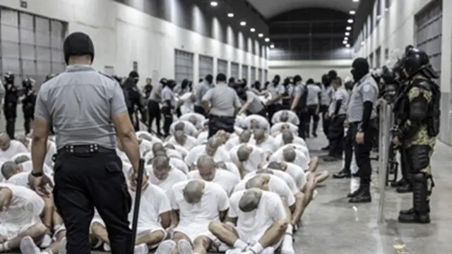 Dalam foto yang disediakan oleh kantor pers kepresidenan El Salvador, para sipir penjara memindahkan para tahanan yang dideportasi dari Amerika Serikat, yang diduga sebagai anggota geng Venezuela, ke Pusat Penahanan Terorisme di Tecoluca, El Salvador.