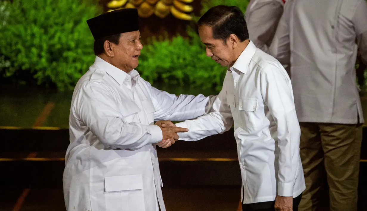 Presiden Republik Indonesia Prabowo Subianto (kiri), yang juga Ketua Umum Partai Gerakan Indonesia Raya (Gerindra), dan Presiden Republik Indonesia ke-7 Joko Widodo saling menyapa di atas panggung pada puncak perayaan ulang tahun ke-17 Partai Gerindra di Sentul International Convention Center (SICC), Bogor, Jawa Barat, Sabtu (15/2/2025). (ADITYA AJI/AFP)