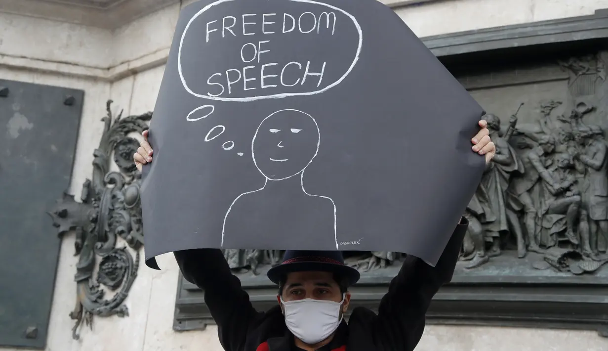 Seorang demonstran memegang plakat di alun-alun Republique selama demonstrasi di Paris (18/10/2020). Mereka berkumpul untuk memberi penghormatan kepada guru sejarah, Samuel Paty yang dipenggal kepalanya di Paris setelah mendiskusikan karikatur Nabi Muhammad di kelasnya. (AP Photo/Michel Euler)