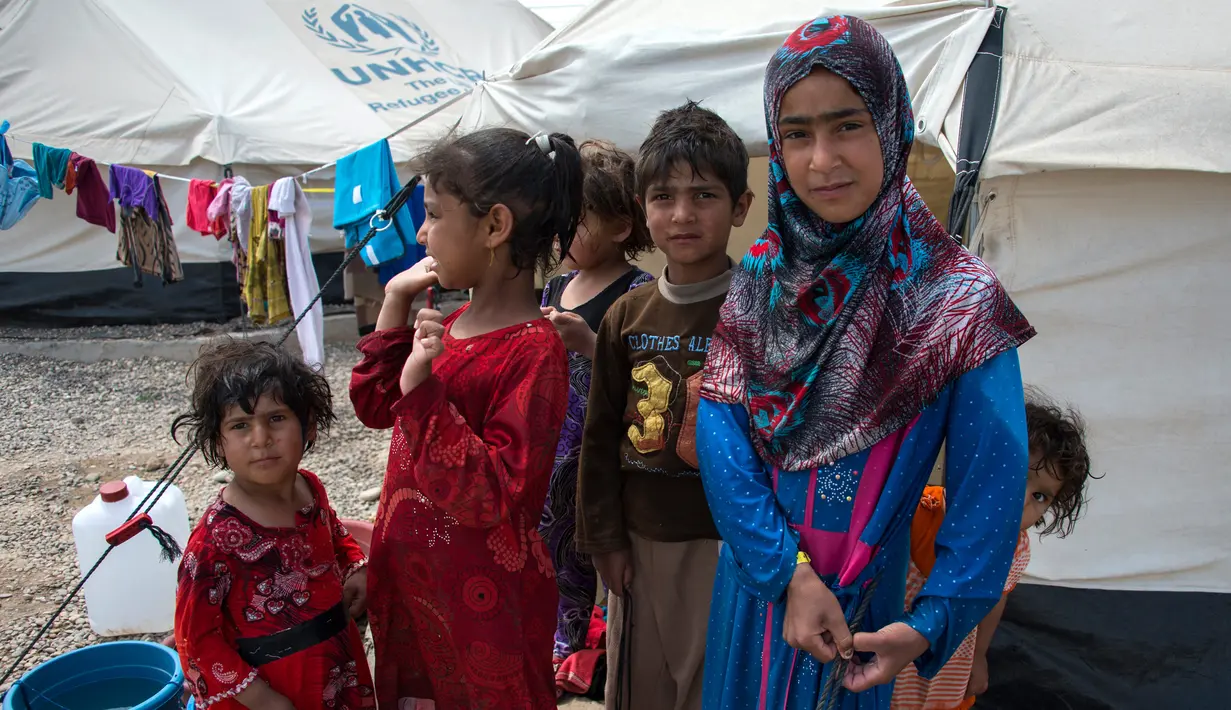 Bocah-bocah berkumpul di di kamp penampungan di Hammam al-Alil, Irak, Rabu (3/5). Pengungsi di kamp ini adalah warga Irak yang menyelamatkan diri dari ISIS di Mosul Barat. (AFP PHOTO / FADEL SENNA)