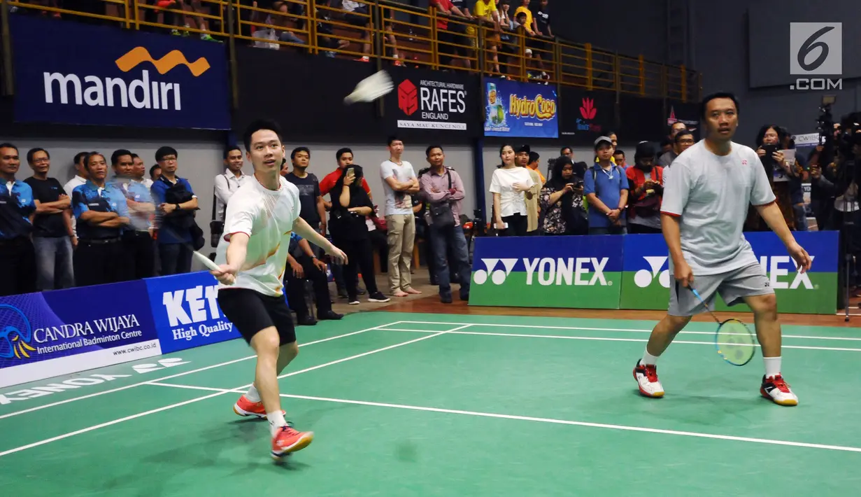 Menpora Imam Nahrawi (kanan) berpasangan dengan Kevin Sanjaya pada laga eksebisi melawan Candra Wijaya/Ricky Subagja di Candra Wijaya Internasional Badminton Centre, Tangerang Banten, Selasa (19/12). (Liputan6.com/Helmi Fithriansyah)