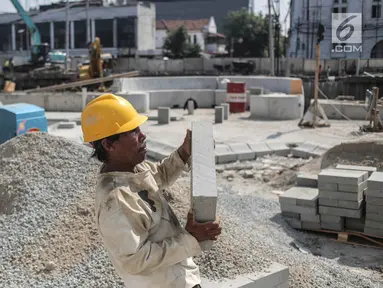 Pekerja mengangkat batu saat pengerjaan proyek revitalisasi kawasan Kota Tua di Jakarta, Jumat (15/9). Revitalisasi kawasan Kali Besar menjadi bagian dari program revitalisasi kawasan kota Tua. (Liputan6.com/Faizal Fanani)
