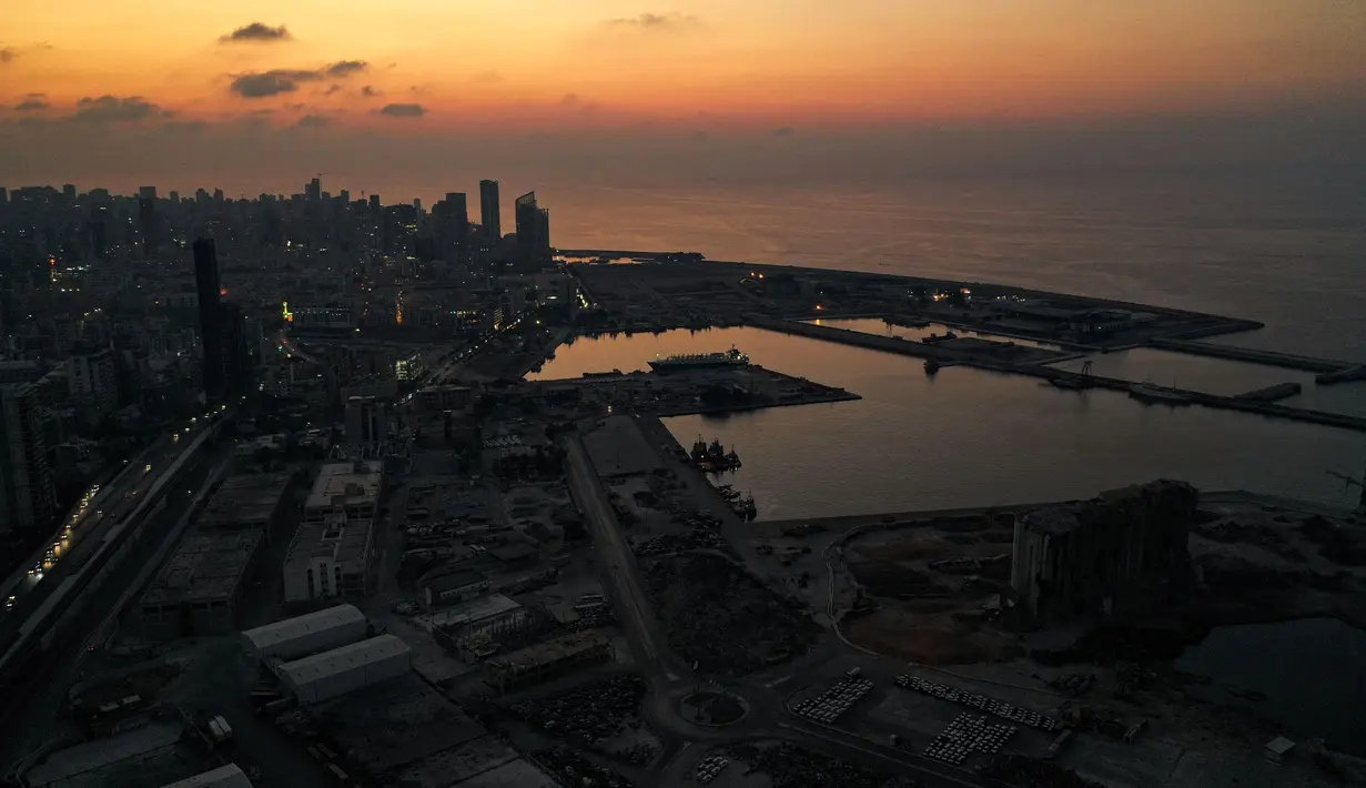 Gambar yang diambil pada 11 Oktober 2021 ini menunjukkan pemandangan udara saat senja di daerah pelabuhan yang hancur di ibu kota Lebanon, Beirut, dalam kegelapan selama pemadaman listrik. Selama 18 bulan terakhir, Lebanon telah mengalami krisis ekonomi dan kekurangan bahan bakar ekstrem. (AFP)