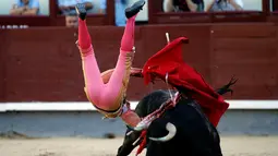 Matador asal Spanyol, Pablo Belando terlempar ke udara usai diseruduk oleh banteng saat bertarung di arena adu banteng Ventas di Madrid (24/7). (REUTERS / Javier Barbancho)