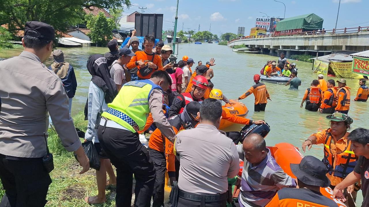 Personel Polres Kudus, TNI, BPBD dan instansi terkait serta relawan membantu proses evakuasi warga Karanganyar di barak pengungsian di perbatasan Kudus dan Demak. (Liputan6.com/Arief Pramono)