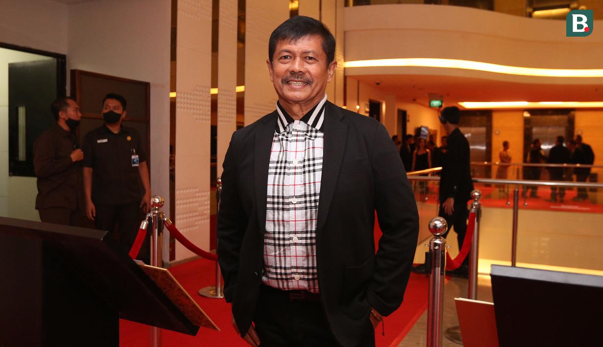 Pelatih kepala Timnas Indonesia U-22, Indra Sjafri berjalan di atas karpet merah pada sebuah acara yang berlangsung di Hotel JS Luwansa, Kuningan, Jakarta, Rabu (19/07/2023). Coach Indra terlihat mengenakan jas hitam dipadukan dengan kemeja bermotif kotak-kotak. (Bola.com/Bagaskara Lazuardi)