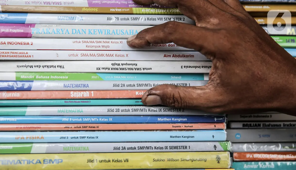 Pedagang memeriksa buku dagangannya di kawasan Kwitang Jakarta, Jumat (26/6/2020). Sejumlah pedagang mengaku penjualan buku mengalami penurunan hingga 50 persen karena imbauan Pemerintah untuk tinggal dirumah dan libur sekolah selama pandemi COVID-19. (Liputan6.com/Faizal Fanani)