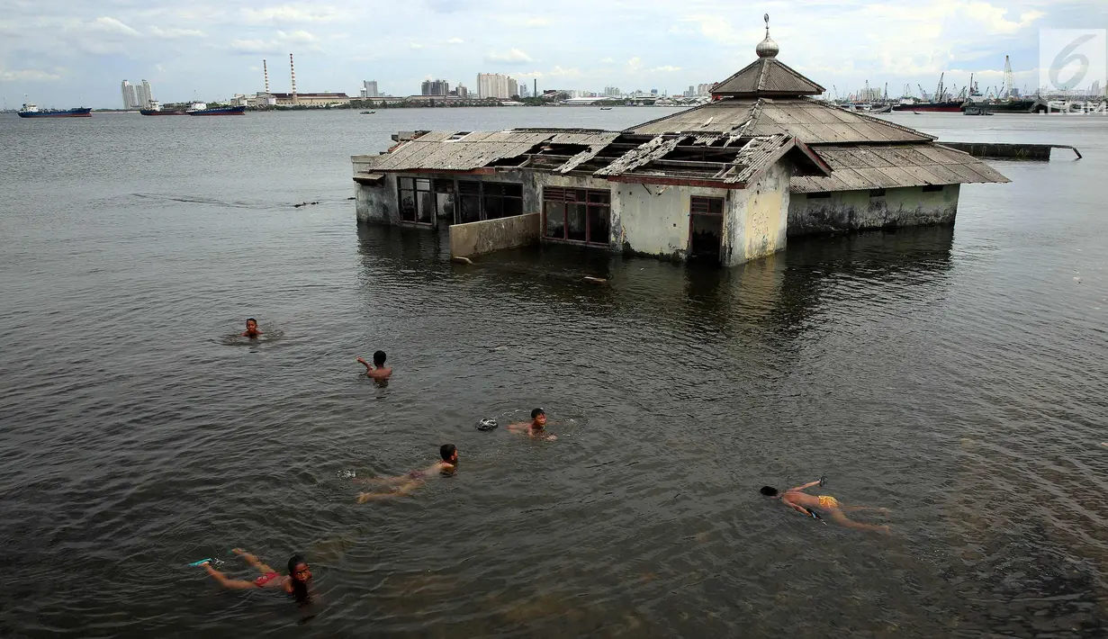 Sejumlah anak bermain di dekat Masjid yang terkena Abrasi di kawasan Muara Baru, Jakarta, Kamis (4/1). Sebagian anak-anak yang bermukim di kawasan tersebut banyak menghabiskan waktu saat berlibur sekolah untuk bermain di laut. (Liputan6.com/Johan Tallo)