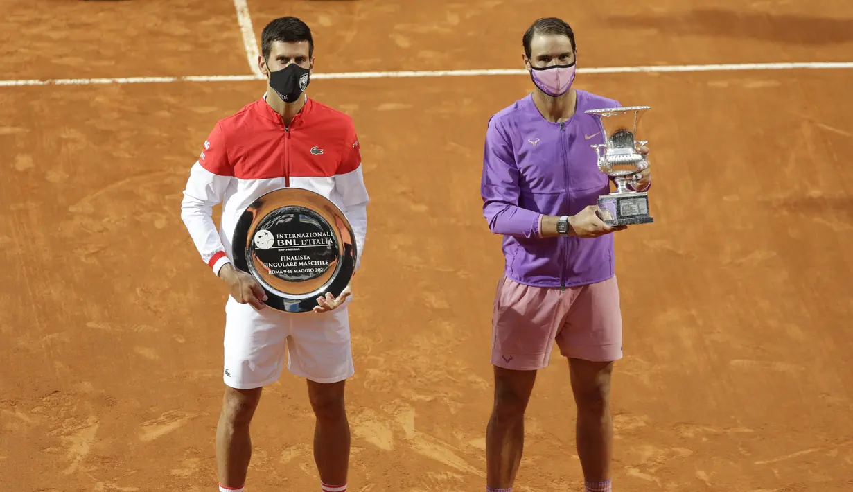 Pemenang Italia Terbuka 2021, Rafael Nadal dari Spanyol (kanan) dan juara kedua, Novak Djokovic dari Serbia berpose dengan trofi mereka usai turnamen tenis di Roma, Minggu (16/5/2021). Nadal mengalahkan Djokovic tiga set 7-5, 1-6, dan 6-3. (AP Photo/Gregorio Borgia)