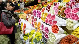 Seorang wanita melihat bunga jelang Hari Perempuan Internasional di pasar bunga Moskow (5/3). Hari Perempuan Internasional pertama kali dirayakan tanggal 28 Februari 1909 di New York dan diselenggarakan Partai Sosialis AS. (AFP Photo/Kirill Kudryavtsev)