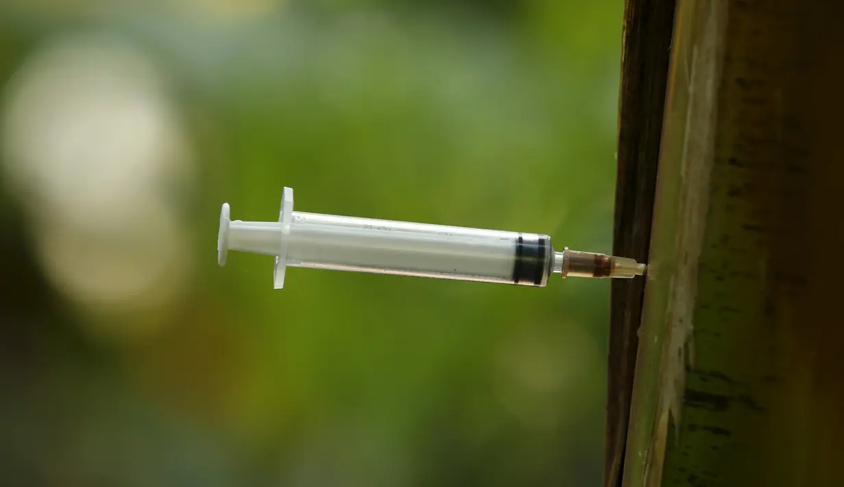 Jarum suntik heroin bekas para pecandu narkoba tertancap pada pohon pisang di Hanoi ,Vietnam, Selasa (1/12). Sejak 2005  remaja di Asia Pasifik meninggal karena AIDS meningkat dua kali lipat.  (REUTERS/Kham)