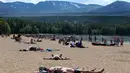 Orang-orang berjemur di pantai di Loch Morlich dekat Aviemore, di Skotlandia, (28/5). Cuaca panas tengah melanda sebagian besar wilayah di Inggris. (AP Photo/Jane Barlow)