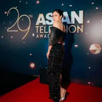 Gaun dengan kombinasi warna cream dan hitam ini memiliki detail off-shoulder dan corset yang memberikan kesan feminin dan anggun.  [@snap.nuel].