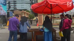 Warga menaruh barang bawaannya sebelum memasuki Polres Jakarta Timur, Rabu (16/5). Sebelumnya telah terjadi serangan dari orang tak dikenal di Mapolda Riau yang menewaskan satu orang polisi pada Rabu (16/5/18) pagi. (Merdeka.com/Imam Buhori)