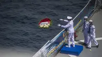KSAL Laksamana TNI Yudo Margono melempar karangan bunga ke laut pada Upacara Tabur Bunga di geladak heli KRI Dr. Soeharso 990 di perairan utara Pulau Bali, Bali, Jumat (30/4/2021). Upacara sebagai penghormatan terakhir bagi awak KRI Nanggala 402 yang gugur dalam medan tugas. (Juni Kriswanto/AFP)