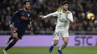 Gelandang Real Madrid, Marco Asensio, berebut bola dengan gelandang Valencia, Daniel Parejo, pada laga La Liga di Stadion Santiago Bernabeu, Madrid, Sabtu (1/12). Madrid menang 2-0 atas Valencia. (AFP/Oscar Del Pozo)