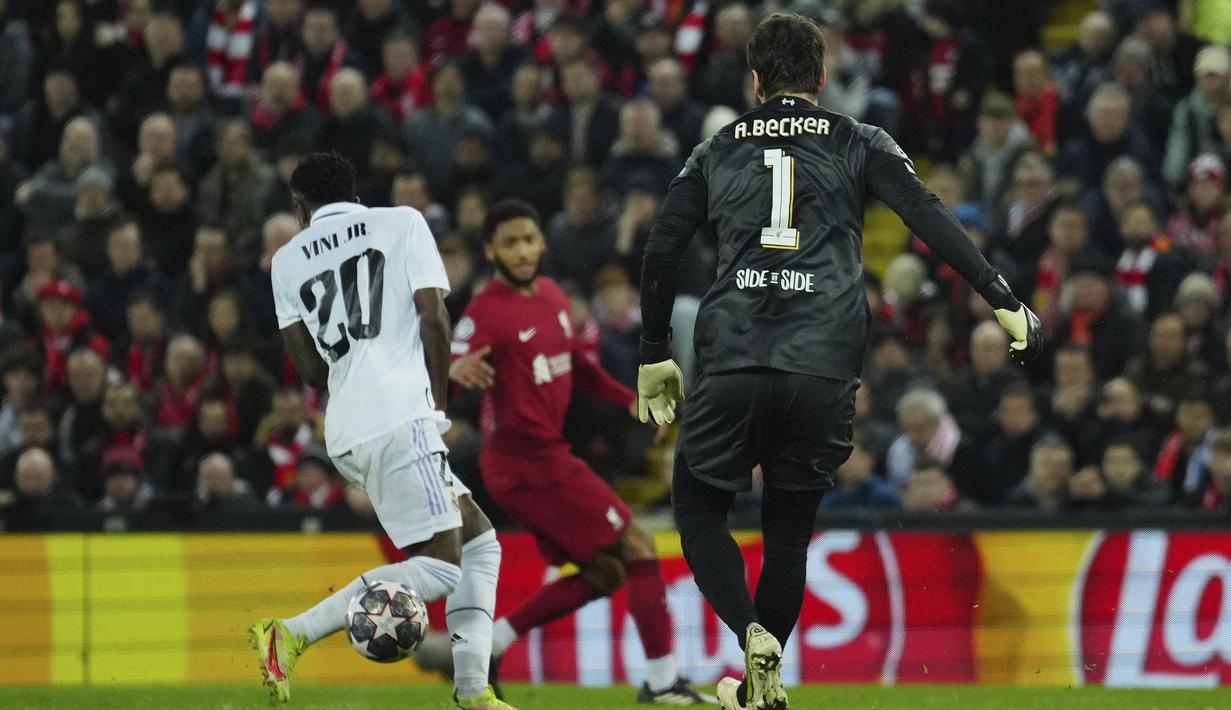 Kiper Liverpool, Alisson Becker (kanan) berusaha menghalau bola namun membentur pemain Real Madrid yang berujung menjadi gol saat laga leg pertama Liga Champions 2022/2023 yang berlangsung di Anfield, Rabu (22/02/2023) WIB. Liverpool kalah dengan skor 2-5 dari Real Madrid. (AP Photo/Jon Super)