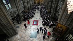 Para tamu dan pejabat mulai mengambil tempat mereka sebelum upacara pemakaman Ratu Elizabeth II di Westminster Abbey di pusat Kota London, Inggris, Senin (19/9/2022). Pemakaman Ratu Elizabeth II melibatkan operasi keamanan terbesar yang pernah ada di London. (AP Photo/Frank Augstein, Pool)