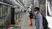 Sejumlah calon penumpang menunggu kedatangan Moda Raya Terpadu (MRT) saat Lebaran di salah satu stasiun di Jakarta, Minggu (24/5/2020). Di tengah pandemi virus corona COVID-19, masyarakat yang biasanya menjadikan MRT sebagai sasaran wisata saat Lebaran kini terpantau sepi. (Liputan6.com/Johan Tallo)