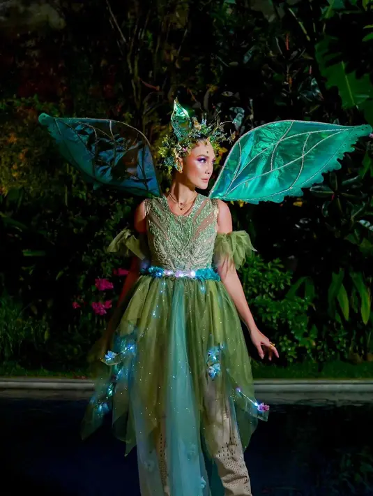 Luna Maya tampil dengan kostum peri berwarna hijau yang ikonis, lengkap dengan sayap dan hiasan kepala berupa dedaunan. [Foto: Instagram/adit_adcee]