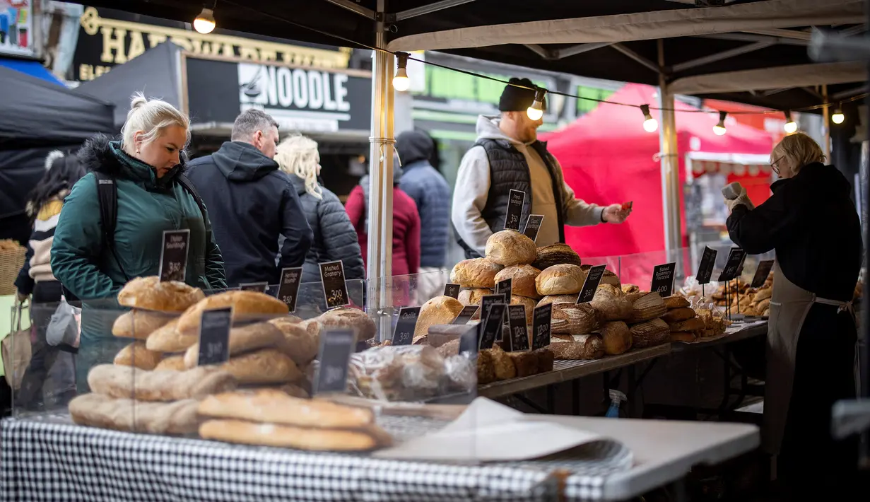 Pelanggan berbelanja roti di kios pasar di Walthamstow, London timur pada 13 Februari 2022. Inflasi tahunan Inggris mencapai 5,4 persen pada Desember, memicu kekhawatiran tekanan biaya hidup karena upah gagal mengimbangi. (Tolga Akmen / AFP)