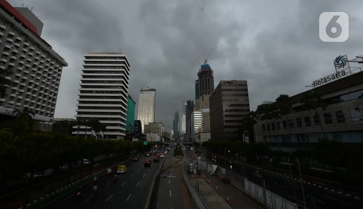 Suasana ibu kota Jakarta diwarnai awan mendung di kawasan Thamrin, Kamis (18/2/2021). Badan Meteorologi, Klimatologi, dan Geofisika (BMKG) memprediksi hujan disertai angin akan terjadi lusa mendatang dan meminta para pengguna jalan harus berhati-hati saat berkendara. (merdeka.com/Imam Buhori)