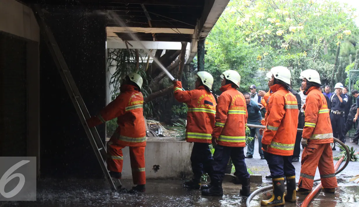 Sejumlah petugas saat menyemprotkan air ke atap rumah yang terbakar di Kebayoran Baru, Jakarta Selatan, Rabu (26/08/15). Penyebab kebakaran belum diketahui tidak ada korban jiwa dalam kebakaran tersebut. (Liputan6.com/Gempur M Surya)
