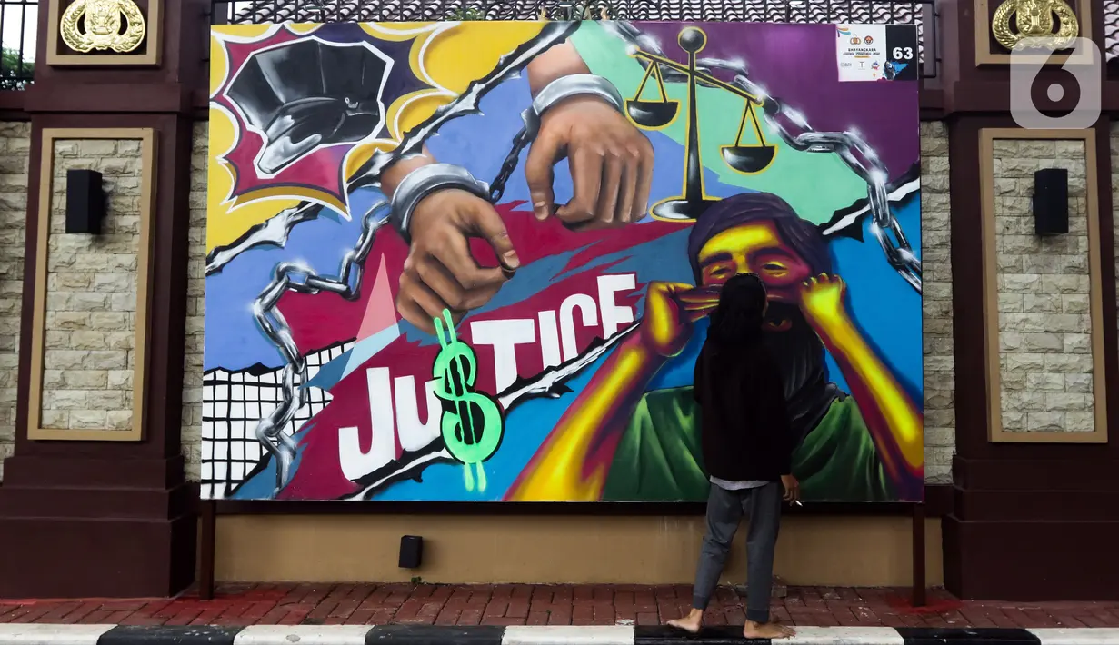 Warga memperhatikan mural berisi kritik terhadap kinerja polisi di Lapangan Bhayangkara Mabes Polri, Jakarta, Minggu (31/10/2021). Sejumlah mural berisi kritik terhadap polisi dipamerkan usai mengikuti ajang Mural Festival 2021 Piala Kapolri 2021. (Liputan6.com/Helmi Fithriansyah)