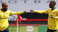 Striker Arsenal Alexandre Lacazette (kiri) merayakan gol Nicolas Pepe ke gawang Sheffield United pada laga Piala FA di Bramall Lane, Minggu (28/6/2020). (AFP/Andrew Boyers)