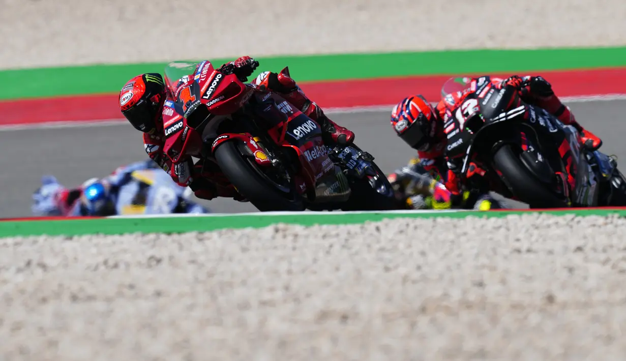 Pebalap Ducati Lenovo, Francesco Bagnaia (kiri) memacu motonya diikuti pebalap Aprilia Racing, Maverick Vinales pada balapan MotoGP Portugal 2023 di Sirkuit Internasional Algarve, Portimao, Portugal, Minggu (26/3/2023). (AP Photo/Jose Breton)