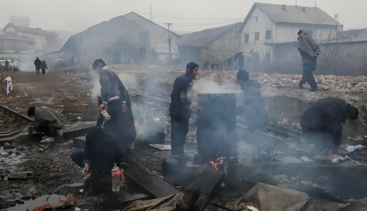 Imigran membersihkan diri di sebuah gudang tak terpakai di Belgrade, Serbia, Kamis (22/12). (REUTERS / Marko Djurica)