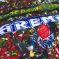Syal Arema FC dan Persebaya Surabaya diletakkan di atas tumpukan bunga duka cita di Stadion Kanjuruhan, Kabupaten Malang, Jumat (7/7/2022). (Bola.com/Bagaskara Lazuardi)