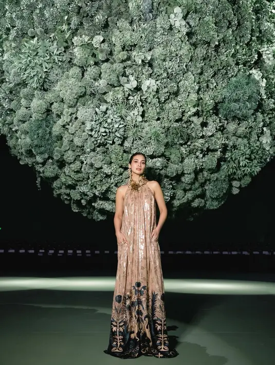 Marsha Timothy terlihat anggun dengan halterneck dress panjang cokelat bermotif gold dan hitam. Kalung emas besar bermotif bunga jadi aksen statement di penampilan istri Vino G Bastian [@marshatimothy]